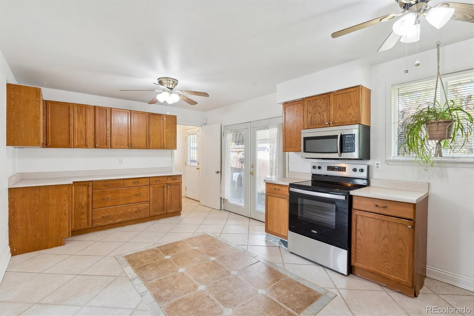 200 Perry Street Denver, CO 80219 - Photo 4 of 24 a kitchen with stainless steel appliances granite countertop a stove cabinets and microwave