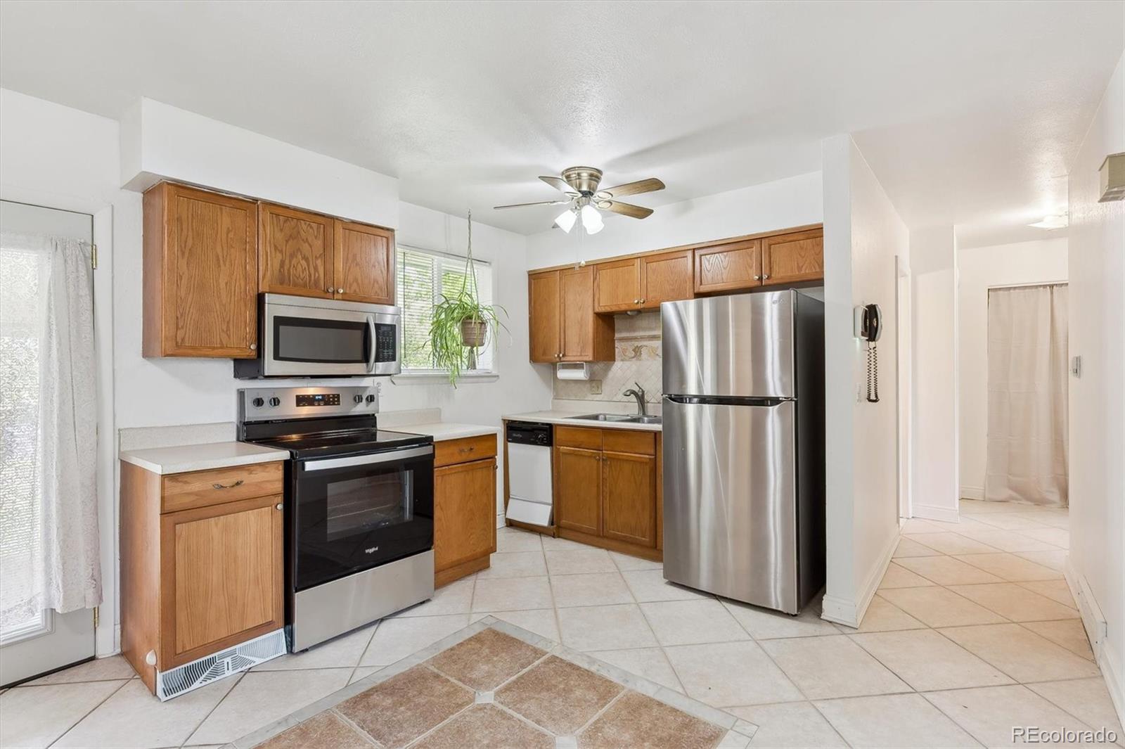 200 Perry Street Denver, CO 80219 - Photo 6 of 24 a kitchen with stainless steel appliances granite countertop a refrigerator a stove top oven a sink and dishwasher