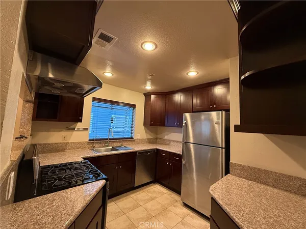 a kitchen with stainless steel appliances granite countertop a refrigerator and a stove