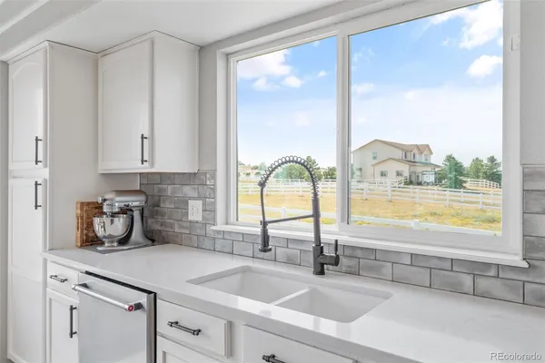 a kitchen with stainless steel appliances cabinets and a large window
