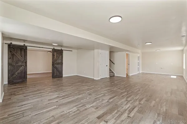 a view of empty room with wooden floor