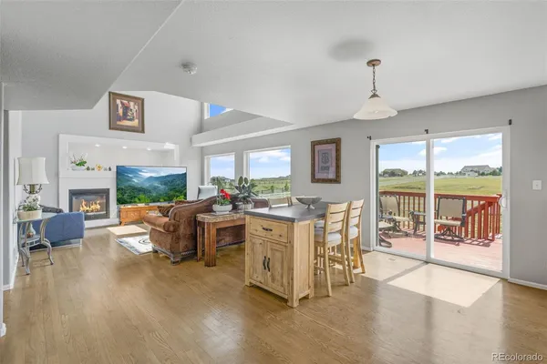 a living room with furniture large window and wooden floor