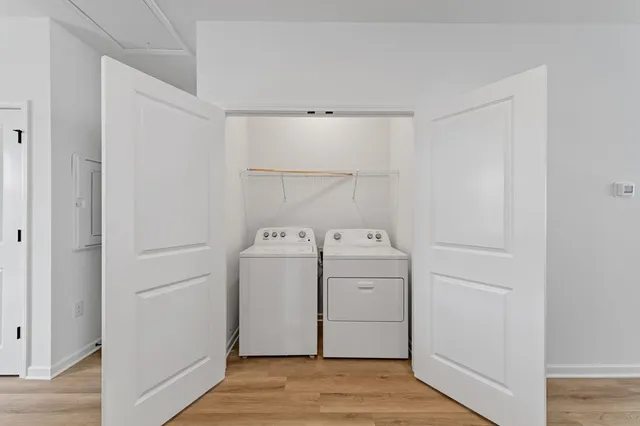 a view of utility room with closet and wooden floor