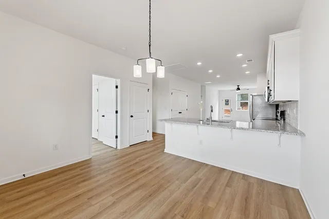 a large kitchen with stainless steel appliances granite countertop a granite counter tops and a wooden floors