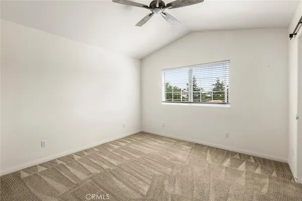 an empty room with closet and a ceiling fan