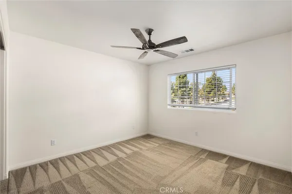 a view of a room with a ceiling fan and a window