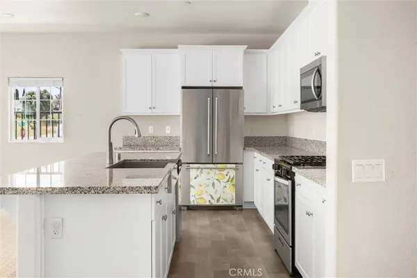 a kitchen with stainless steel appliances granite countertop a stove microwave and sink