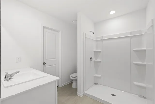 a bathroom with a sink a toilet and shower