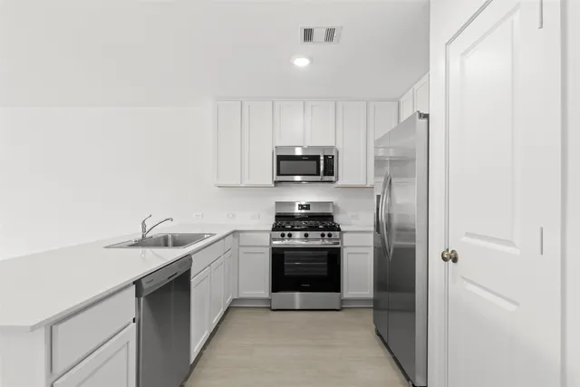 a kitchen with stainless steel appliances granite countertop a sink stove and refrigerator