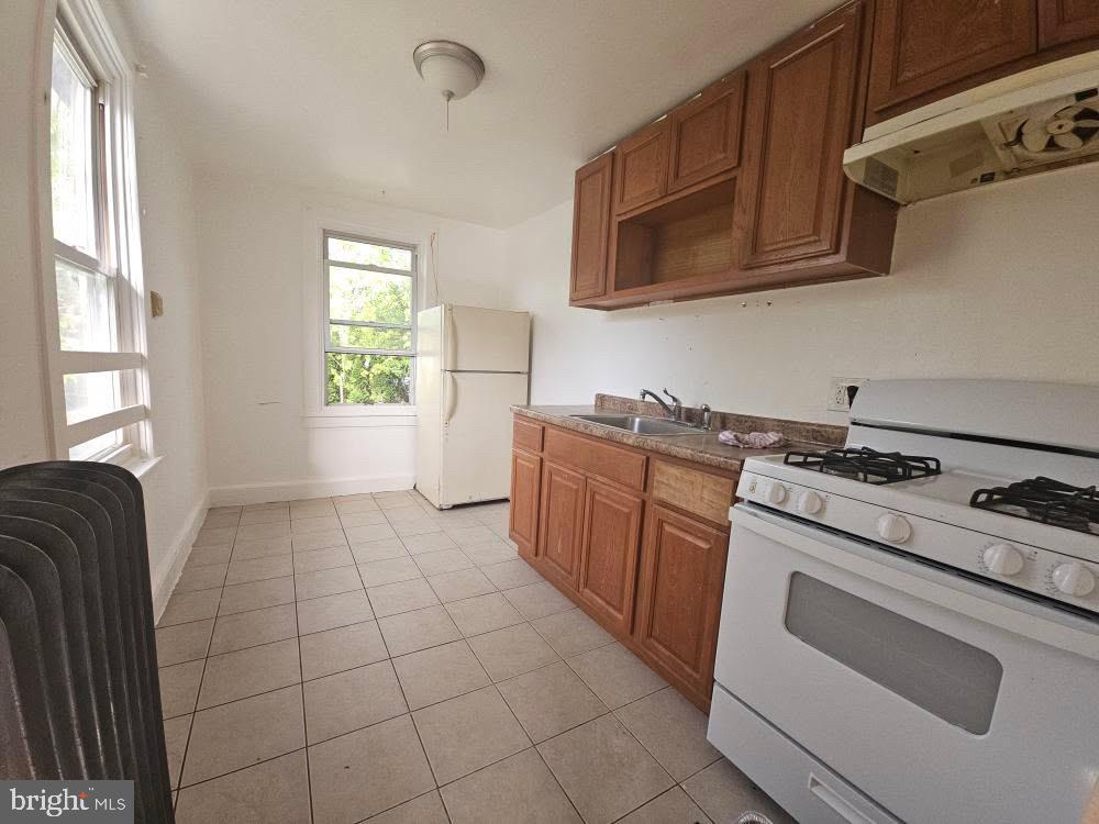 107 East County Line Road, Unit 2 Ardmore, PA 19003 - Photo 4 of 17 a kitchen with granite countertop a stove top oven microwave and cabinets