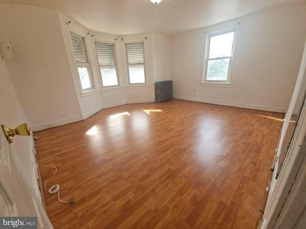 107 East County Line Road, Unit 2 Ardmore, PA 19003 - Photo 7 of 17 an empty room with wooden floor and windows