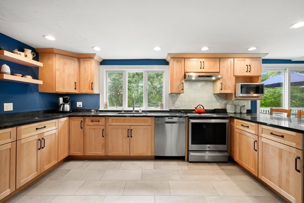 91 Canoe Tree Way Marshfield, MA 02050 - Photo 11 of 35 a kitchen with stainless steel appliances granite countertop a stove sink and cabinets