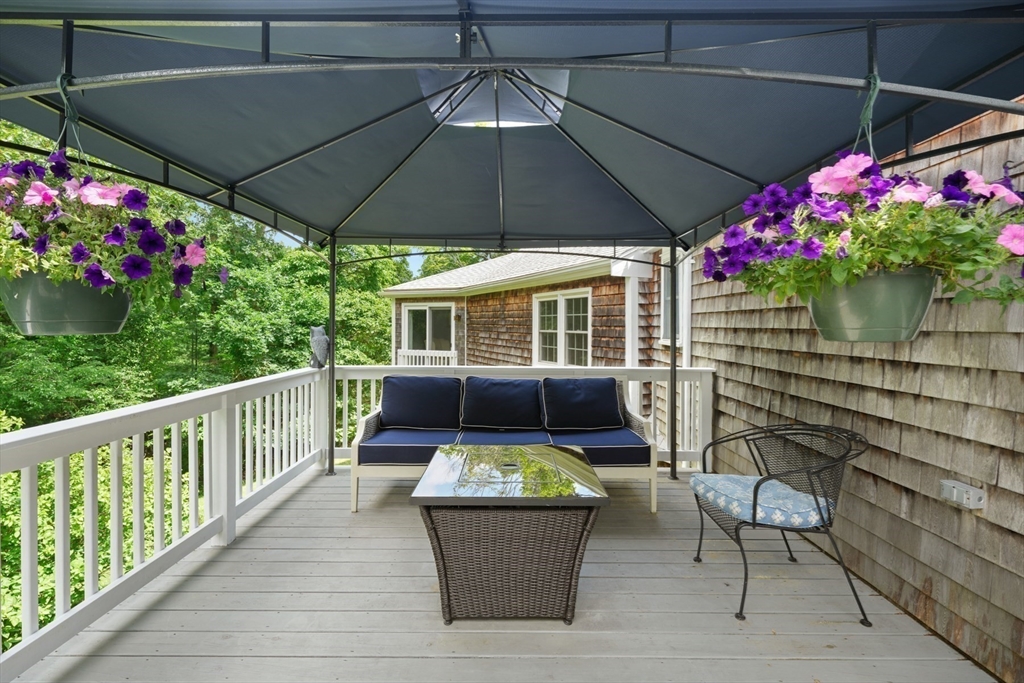 91 Canoe Tree Way Marshfield, MA 02050 - Photo 26 of 35 a view of a chair and tables under an umbrella in the balcony