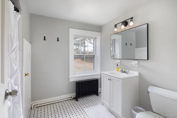 a bathroom with a toilet sink and mirror