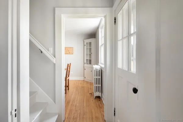 a view of a hallway with wooden floor and staircase