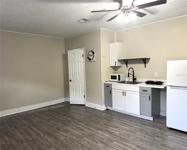 a kitchen with a refrigerator and white cabinets