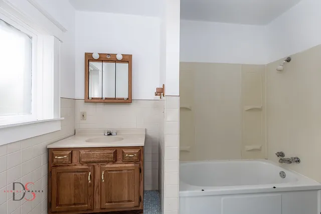 an empty room with windows and hardwood