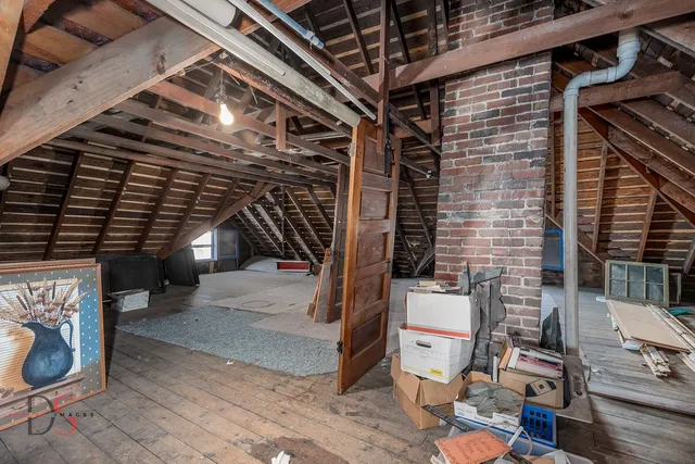 a view of an empty room with window and hardwood floor