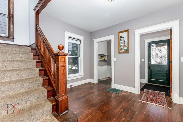 a view of a bedroom with wooden floor & cabinet