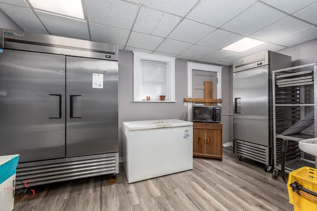 a room with stainless steel appliances kitchen island granite countertop a sink and cabinets