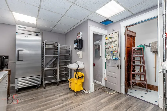 a large living room with stainless steel appliances kitchen island granite countertop furniture and a wooden floor