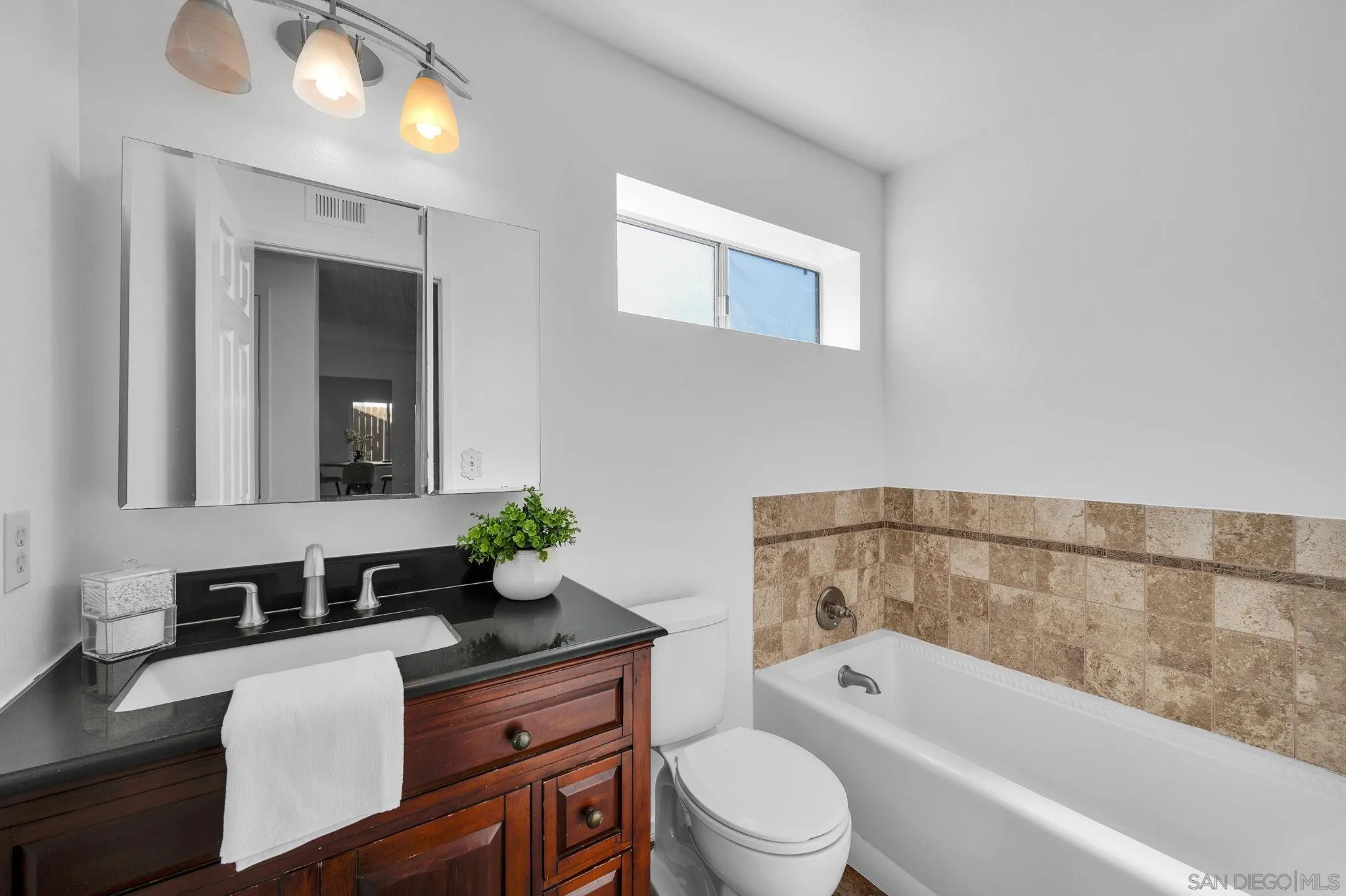 10834 Buggywhip Drive Spring Valley, CA 91978 - Photo 18 of 36 a bathroom with a granite countertop bathtub sink vanity mirror and toilet
