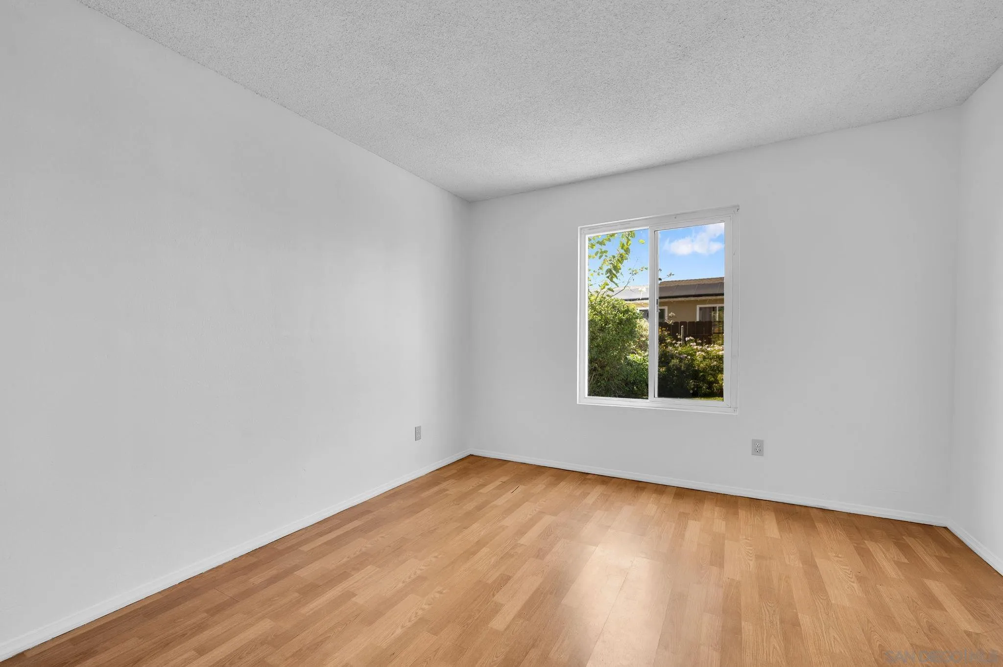 10834 Buggywhip Drive Spring Valley, CA 91978 - Photo 19 of 36 a view of an empty room with wooden floor and a window
