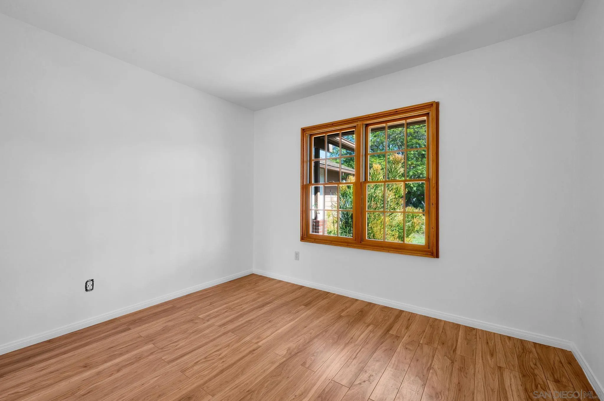 10834 Buggywhip Drive Spring Valley, CA 91978 - Photo 23 of 36 a view of an empty room with wooden floor and a window
