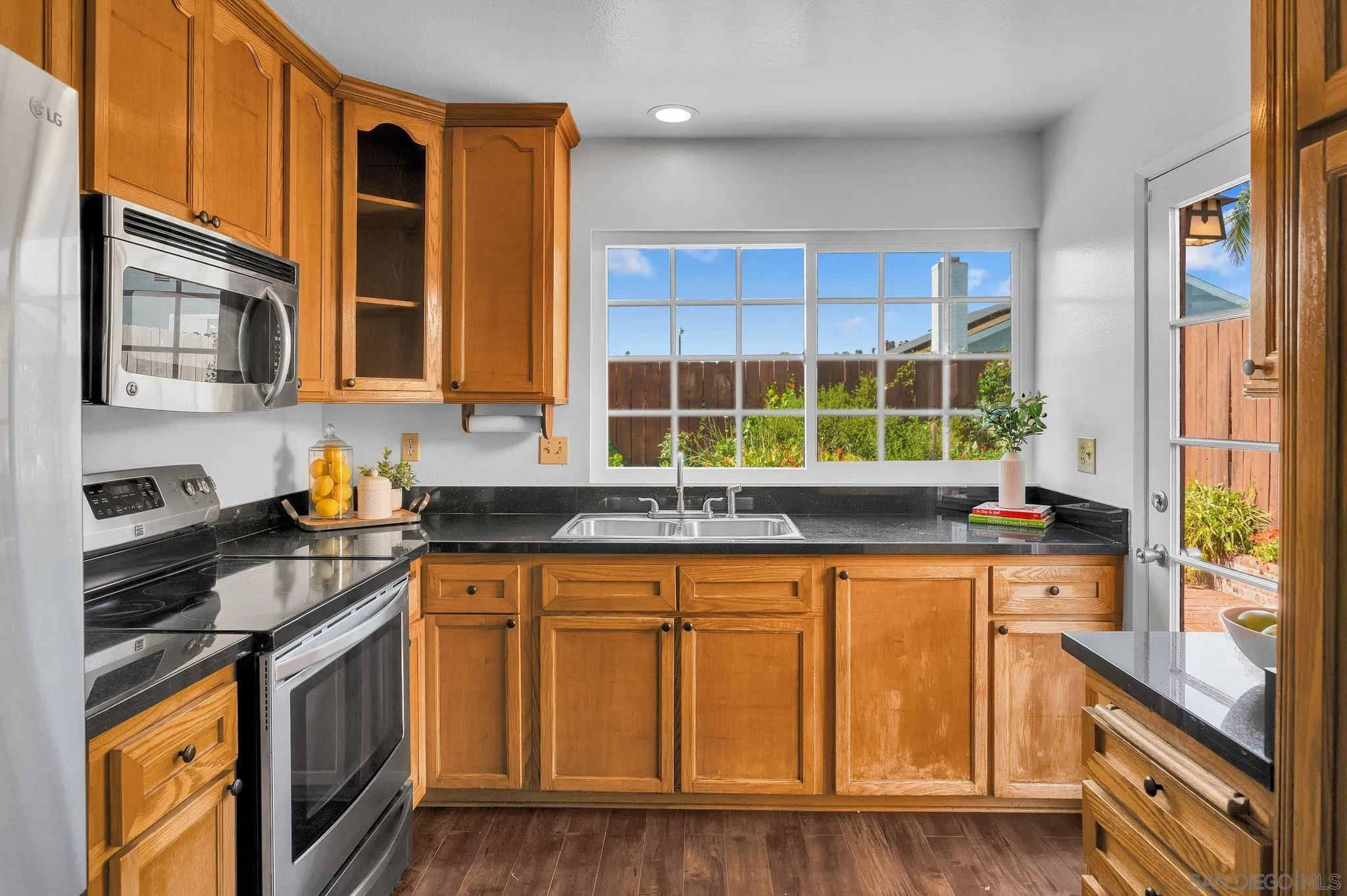 10834 Buggywhip Drive Spring Valley, CA 91978 - Photo 9 of 36 a kitchen with stainless steel appliances granite countertop a stove a sink and a microwave