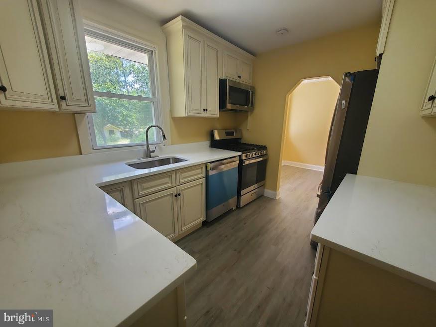 300 Ridge Road Browns Mills, NJ 08015 - Photo 3 of 28 a kitchen with stainless steel appliances granite countertop a sink a stove a refrigerator a sink a window with wooden floor and cabinets