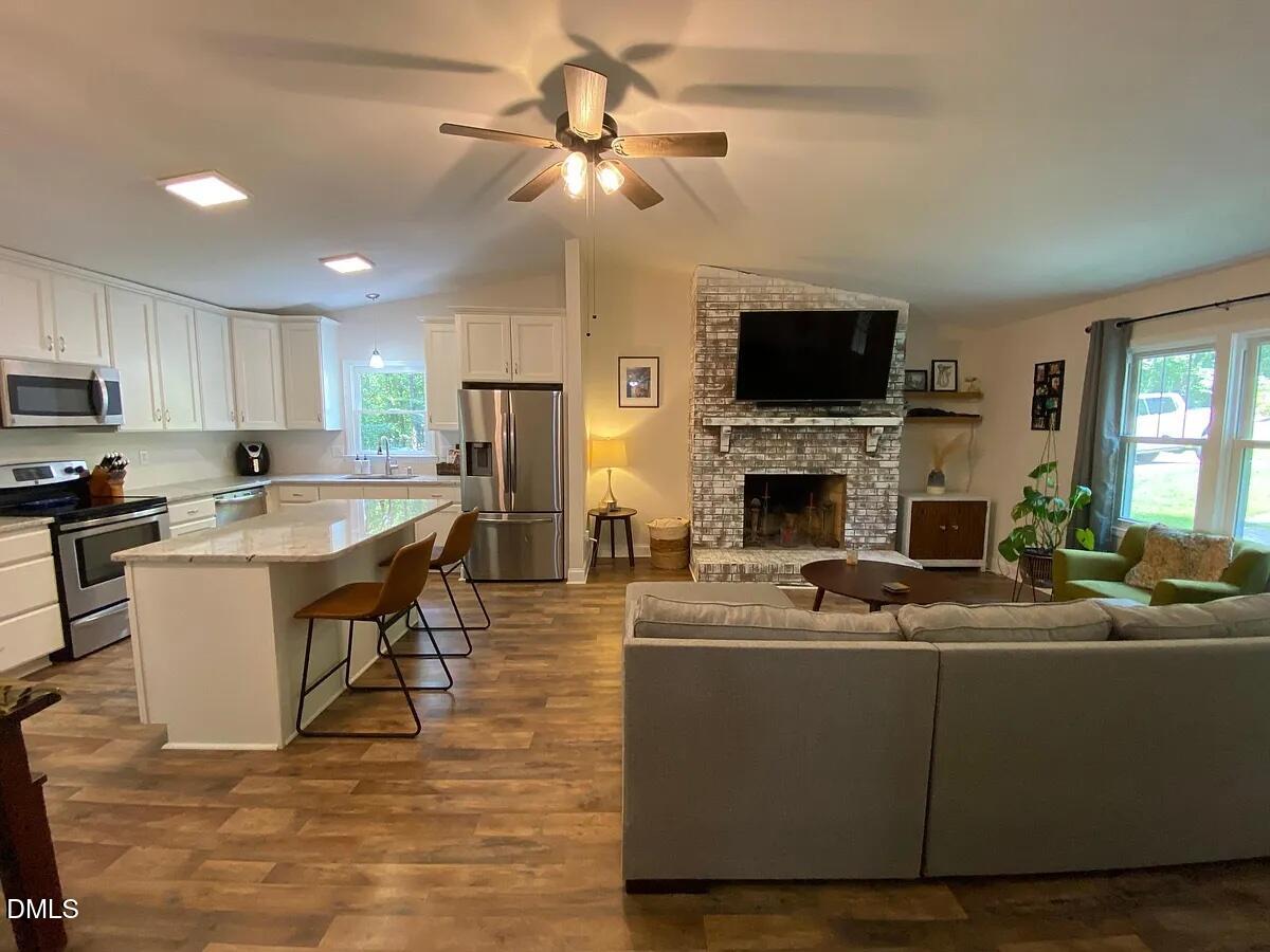 7501 Post Oak Road Raleigh, NC 27615 - Photo 3 of 40 a living room with stainless steel appliances furniture a fireplace a flat screen tv and a fireplace