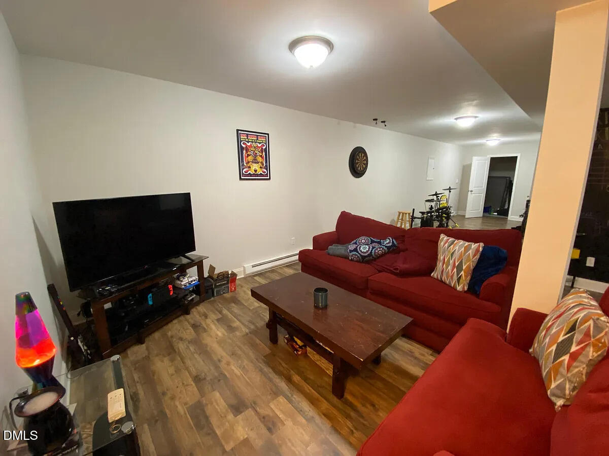 7501 Post Oak Road Raleigh, NC 27615 - Photo 36 of 40 a living room with furniture and a flat screen tv