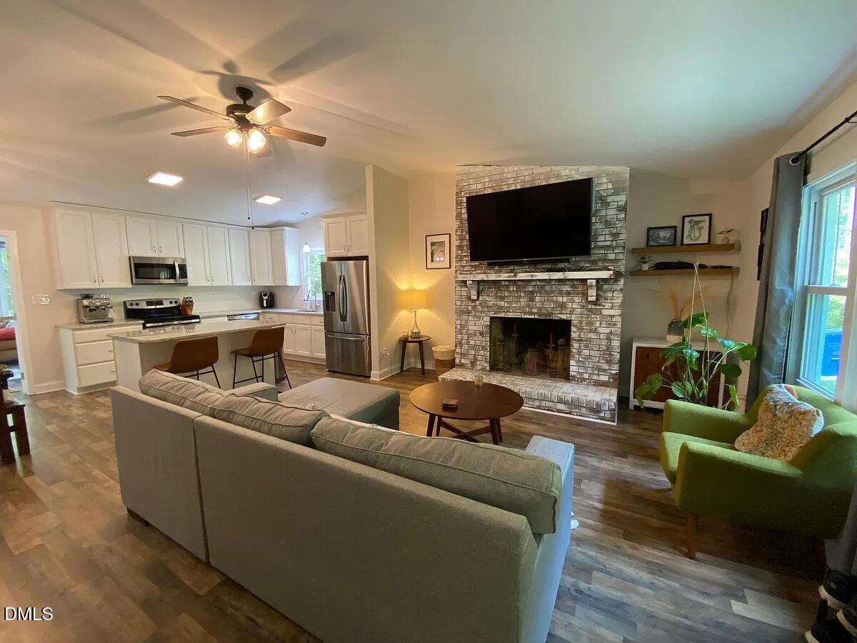 7501 Post Oak Road Raleigh, NC 27615 - Photo 4 of 40 a living room with furniture a flat screen tv and a fireplace