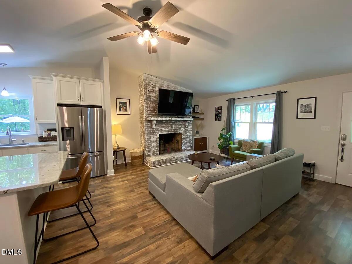 7501 Post Oak Road Raleigh, NC 27615 - Photo 5 of 40 a living room with furniture a flat screen tv and a fireplace
