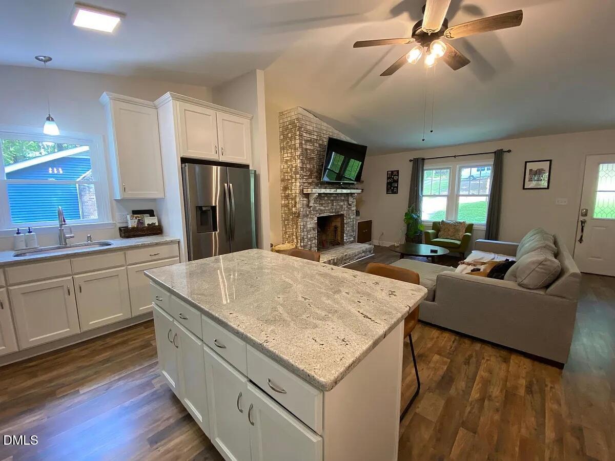 7501 Post Oak Road Raleigh, NC 27615 - Photo 6 of 40 a living room with stainless steel appliances kitchen island granite countertop furniture and a fireplace