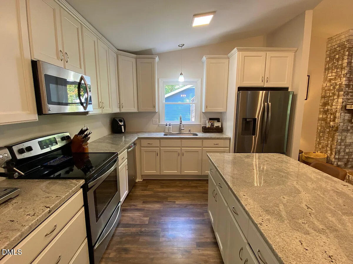 7501 Post Oak Road Raleigh, NC 27615 - Photo 7 of 40 a kitchen with a stove a sink and a refrigerator