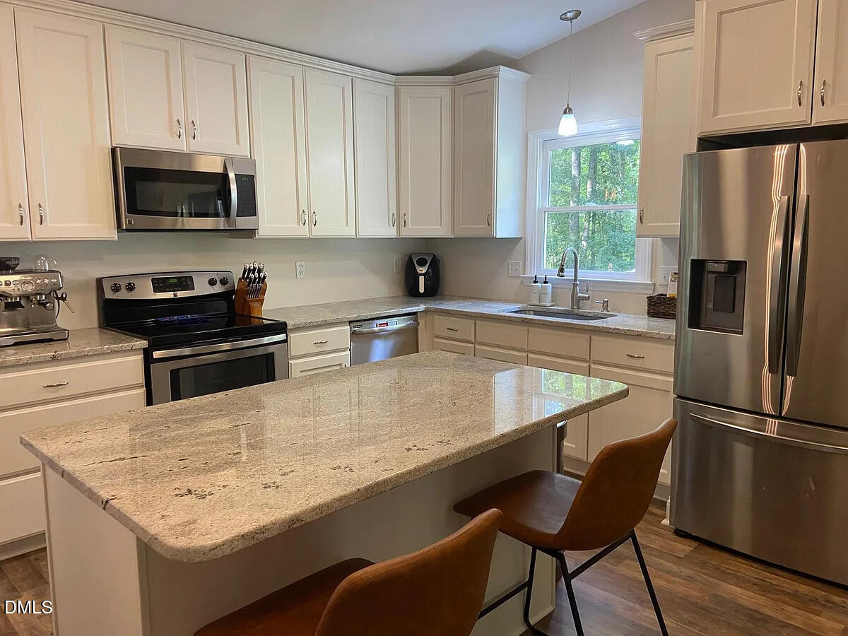 7501 Post Oak Road Raleigh, NC 27615 - Photo 10 of 40 a kitchen with stainless steel appliances granite countertop a sink stove and refrigerator