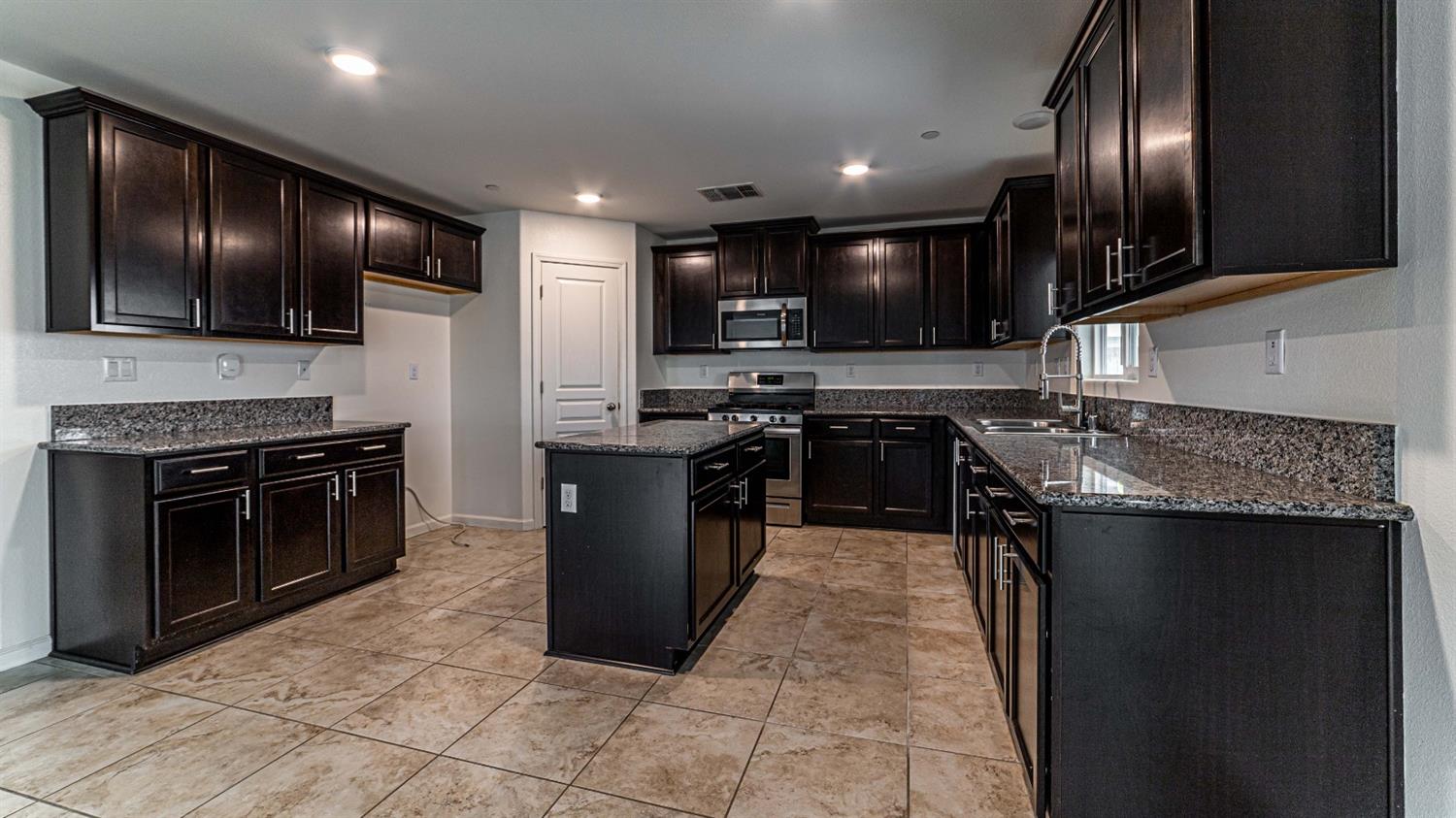 512 Barbara Avenue Sanger, CA 93657 - Photo 13 of 40 a kitchen with stainless steel appliances granite countertop a stove top oven a sink dishwasher a refrigerator and a oven
