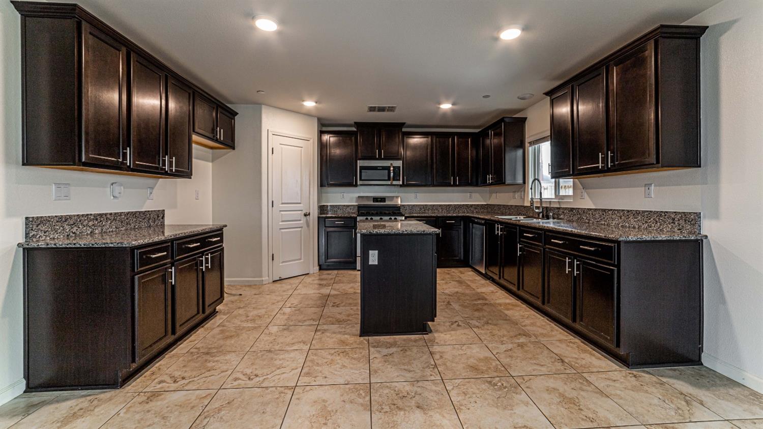512 Barbara Avenue Sanger, CA 93657 - Photo 15 of 40 a kitchen with stainless steel appliances granite countertop wooden cabinets a sink and a stove