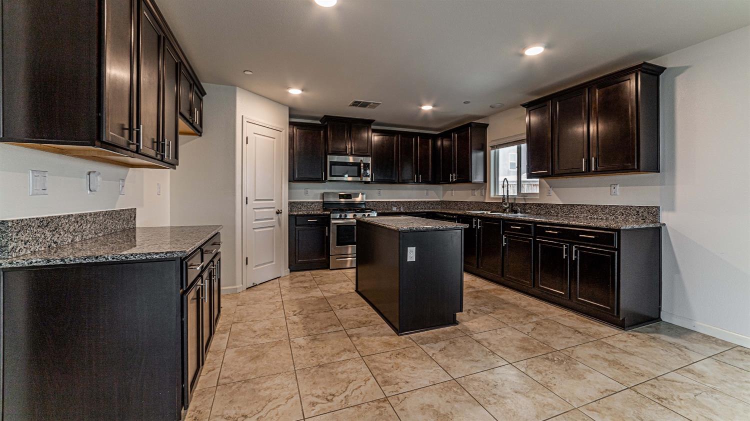 512 Barbara Avenue Sanger, CA 93657 - Photo 16 of 40 a kitchen with stainless steel appliances granite countertop a stove top oven sink and cabinets