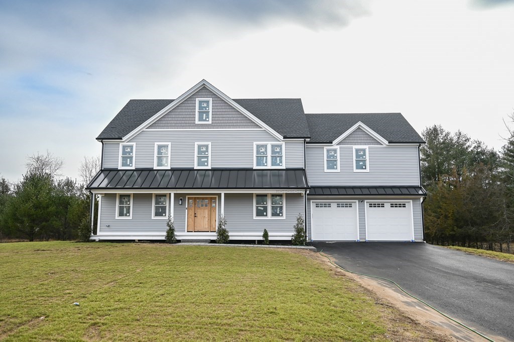 a front view of a house with a garden and yard