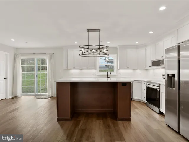 a kitchen with stainless steel appliances granite countertop a stove and a wooden floors