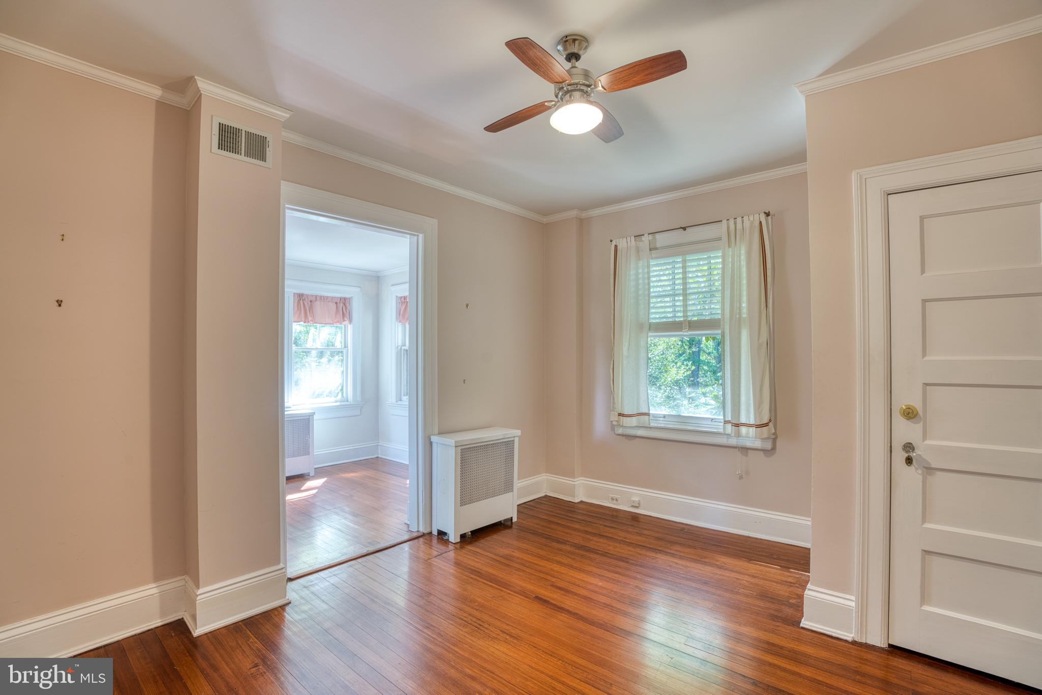 3925 Canterbury Road Baltimore, MD 21218 - Photo 35 of 65 an empty room with wooden floor ceiling fan and windows