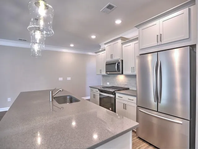 an open kitchen with sink and fireplace