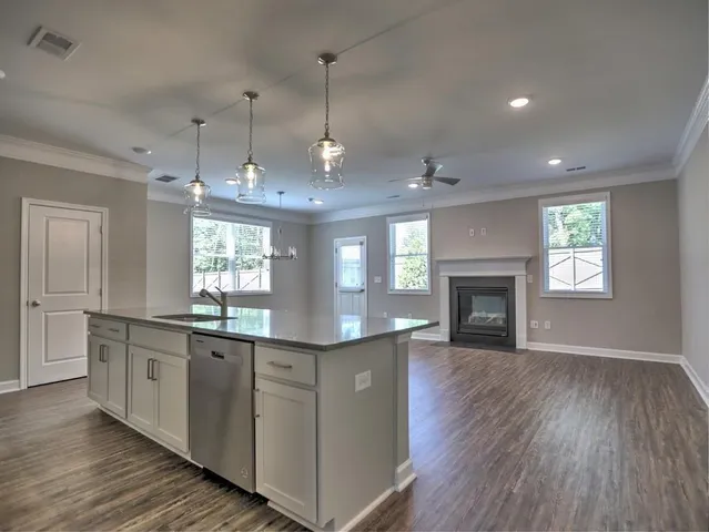 an empty room with windows fireplace and wooden floor
