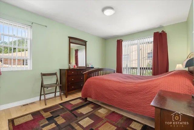 a bedroom with a bed and a dresser next to a window
