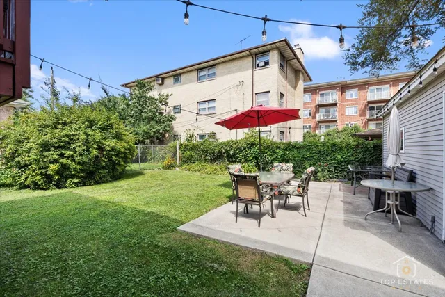 a view of a patio with table and chairs under an umbrella