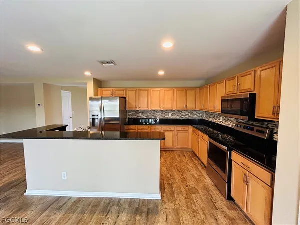 a kitchen with stainless steel appliances granite countertop a refrigerator and a sink