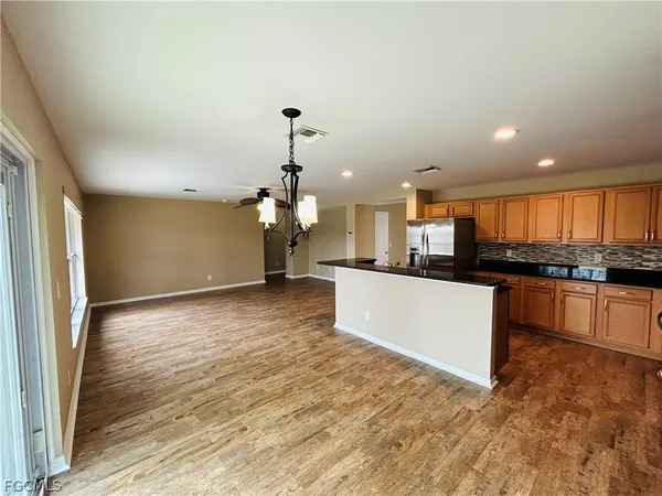 a view of a hallway with wooden floor and dining room