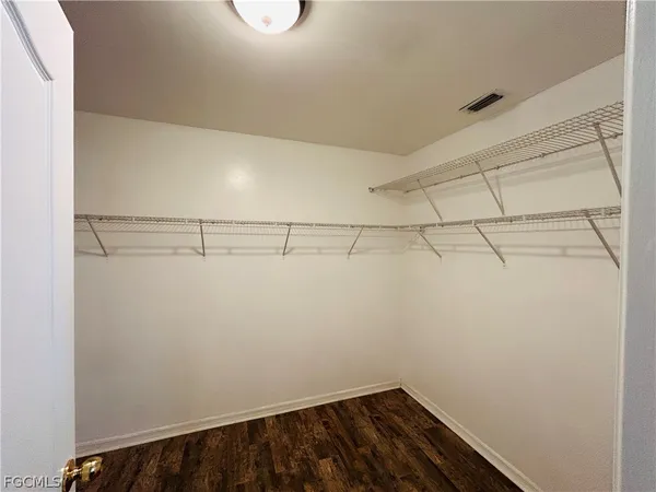 a view of a hallway with wooden floor and a living room